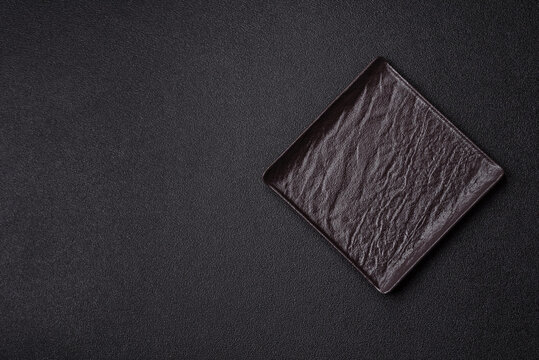 A blank slate board on a dark background for Asian food. A blank slate board