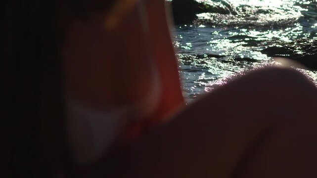 Woman water sunset young woman in white lingerie sits by the shimmering sea during sunset