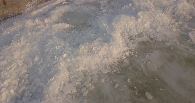 Large frozen river drone flight, chunks of ice near the shore