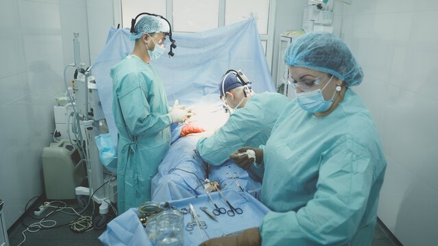 Three doctors in medical uniform perform operation neurosurgery treatment surgeons professional men working with nurse woman preparing bandage practitioners medicine surgery work health life insurance