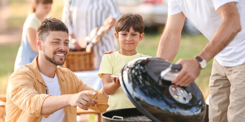 Happy family at barbecue party on summer day