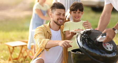 Happy family at barbecue party on summer day