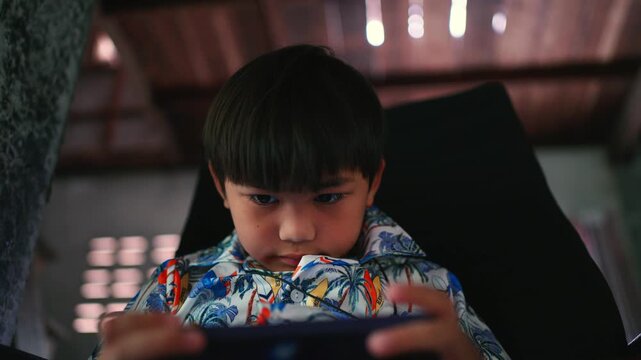 The little child was playing the game intently, staring intently at the screen.