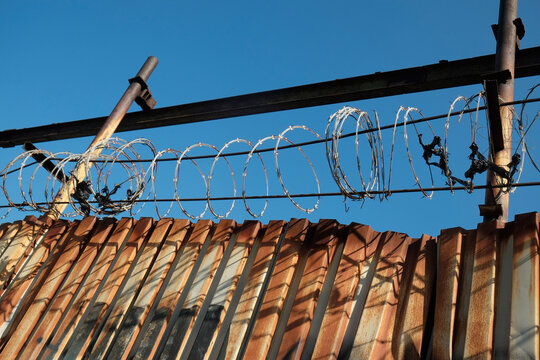 Barbed Wire Fence Against Blue Sky
