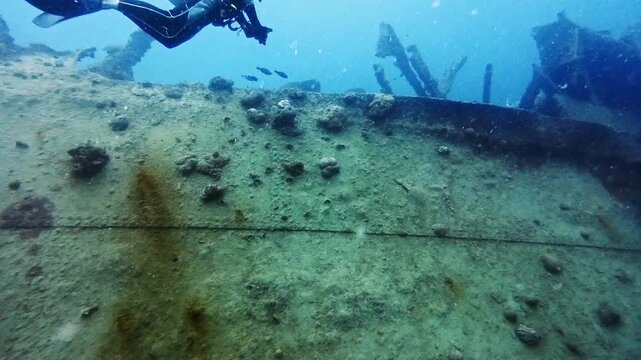 Scuba Diver Swimming Along the Edge of SMS Cormoran II Wreck, Guam