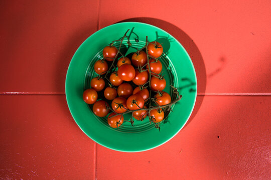 Tiny cherry tomatoes ciliegini, pachino, cocktail. group of cherry tomatoes on a color concrete background.