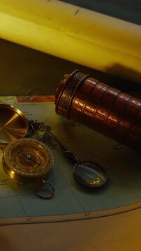 Vertical macro slide across candlelight reveals a cryptex, compass, and scrolls, evoking coded secrets and atmospheric discovery.