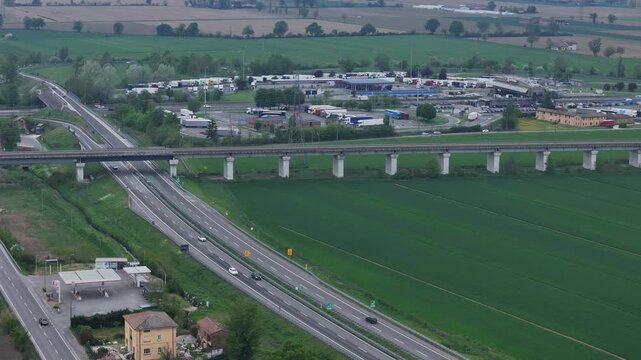 Autostrada A1 and A21 junction near Fiorenzuola d&rsquo;Arda Piacenza Emilia Romagna Italy with viaduct crossing farmland and connection to Via Emilia SS9 and toll area, drone telephoto shot