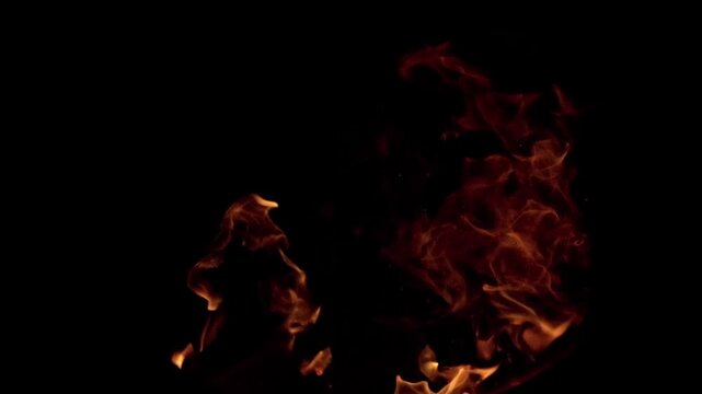 Cinematic 4K vertical shot of intense, roaring fire pit flames isolated against a pure black background. Perfect for social media formats and VFX blending modes.