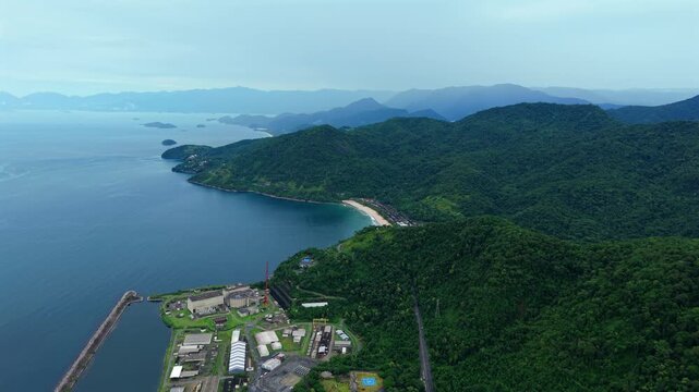 Drone footage of the Usina Nuclear Angra facility situated along the scenic Brazilian coastline.