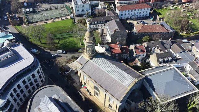 St Peter Port Guernsey,dropping,circling overhead footage of St James Assembly hall then pulling away with views to the harbour in bright late afternoon sun