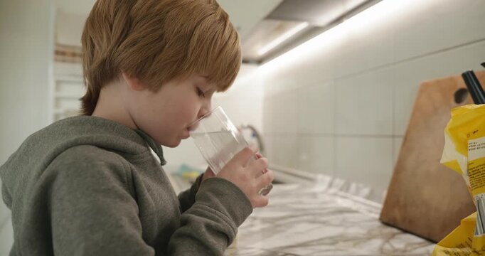 Kid Boy Drinks Glass of Water in Kitchen. 4K 10-bit