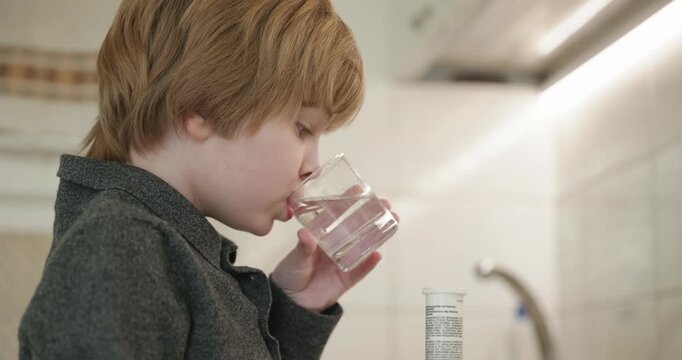 Kid Boy Drinks Glass of Water in Kitchen. 4K 10-bit