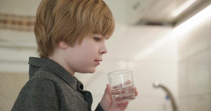 Kid Boy Drinks Glass of Water in Kitchen. 4K 10-bit