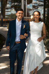 Naklejka premium Happy bride and groom walking and embracing outdoors in romantic wedding setting