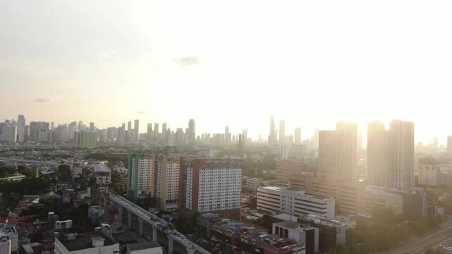 Jakarta, Indonesia - April 26th 2026: Aerial View of Densely Populated City with Heavy Smog and Air Pollution. Urban Landscape Featuring Elevated Rail Construction, Colorful Apartments, and High-rise
