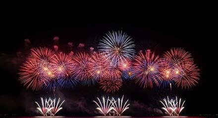 Fototapeta premium Vibrant fireworks display on 4th of July celebration at night with red white and blue colors lighting up the sky