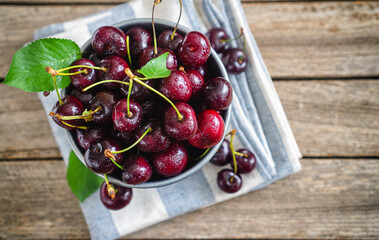 Fresh sweet cherries in a bucket on an old wooden background © k2photostudio
