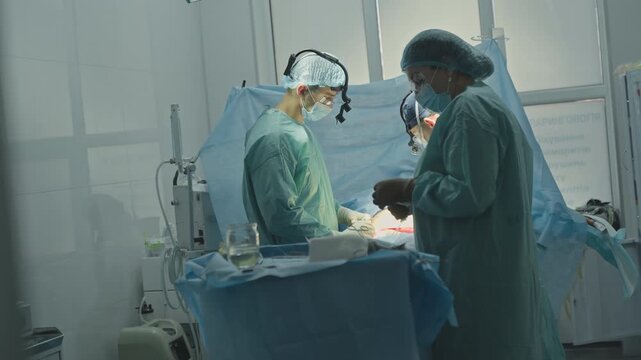 Surgery operating process medication of trauma three medics doctor with nurses assistants team cooperating in clinic hospital emergency surgical operation cardio heart neurosurgery surgeon saving life