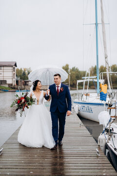young couple, the bride and groom, walking along a pier