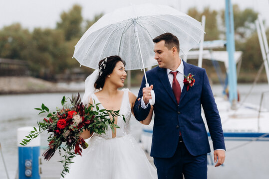 young couple, the bride and groom, walking along a pier