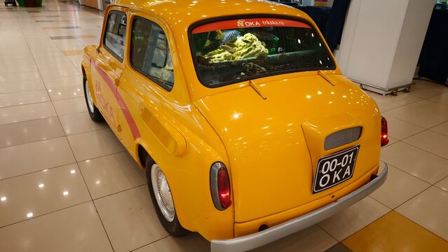 Kolpino, Russia - April 17, 2026: Yellow ZAZ 965 car displayed indoors with a visible license plate and retail environment