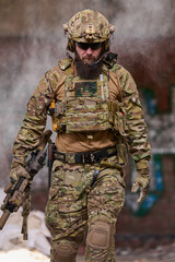 Obraz premium Armed Tactical Soldier in Camouflage Gear and Helmet Holding Rifle During Urban Military Operation