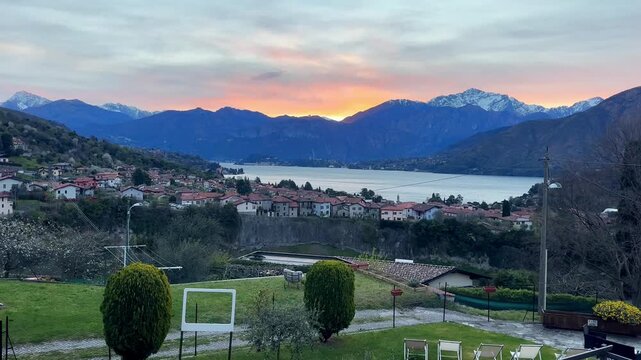Lake como sunset panorama with village and garden overlooking lake and mountains under colorful sky serene italian landscape travel destination