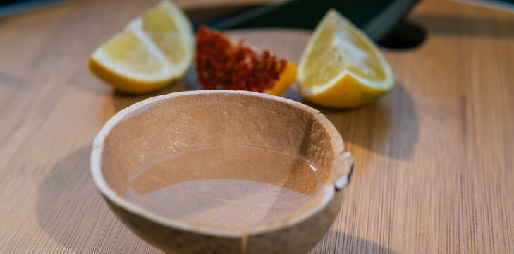 Mezcal in a jicara cup with orange slices