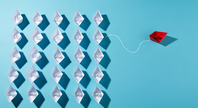 A single red paper boat sails away from a formation of white paper boats, symbolizing individuality and independence.