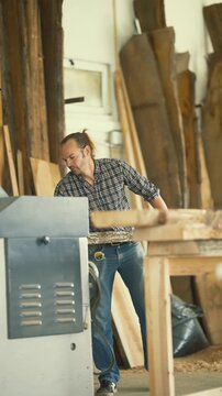 Carpenter using a thickness planer woodworking machine