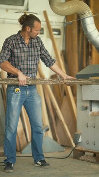 Carpenter processing a raw log on a planing machine