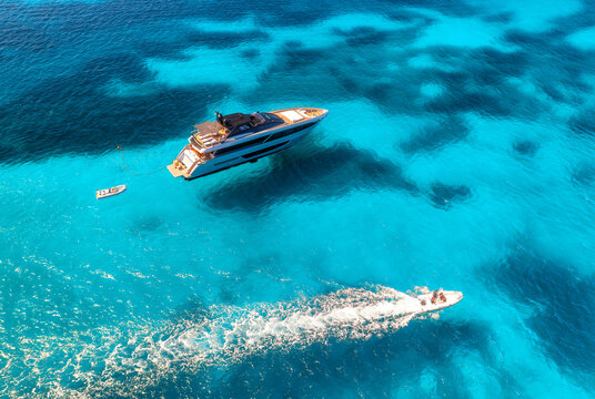 Aerial drone view of beautiful luxury yachts and boats in blue sea in summer. Sardinia, Italy. Top down view of speed boats, turquoise water. Tropical landscape. Yachting. Seascape. Summer vibe