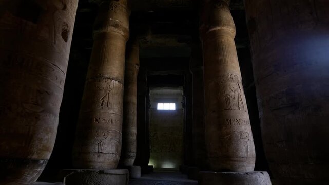Sacred hypostyle hall at Abydos temple of Seti I, Egypt, ancient columns with carved hieroglyphics and gods receding in atmospheric perspective toward illuminated sanctuary.