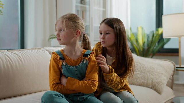 Two Caucasian kids children conflict little younger girl offended ignoring older sister talking apologize sorry talk ask forgiveness girls sisters siblings daughters quarrel misunderstanding at home