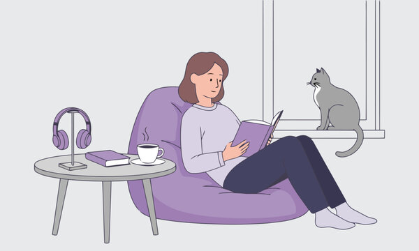 Woman sitting on a purple bean bag chair reading a book with a cat