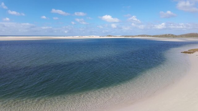 4k 30fps footage of the Heuningnes River estuary at De Mond Nature Reserve, Overberg, Western Cape. South Africa. Serene coastal wetlands, winding waterways and pristine nature under clear skies.