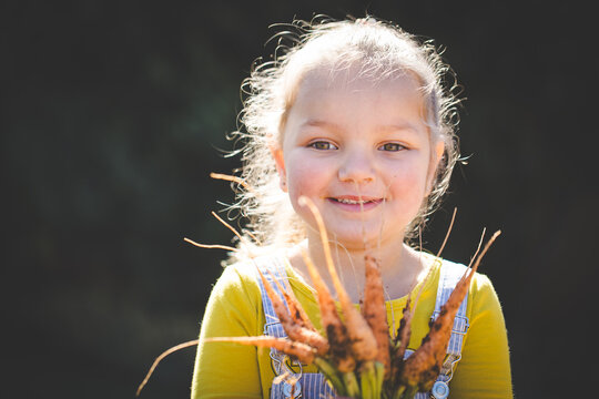 Happy child with garden flowers outdoors