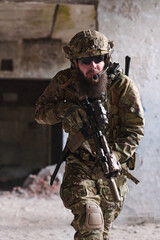 Fototapeta premium Bearded Special Forces Soldier In Tactical Gear Moving Through Urban Combat Environment With Rifle