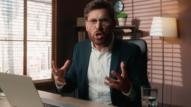 Mad furious Caucasian 40s business man working with laptop yelling looking at camera yell with anger talking rude annoyed middle-aged businessman male talk screaming work computer scream in office