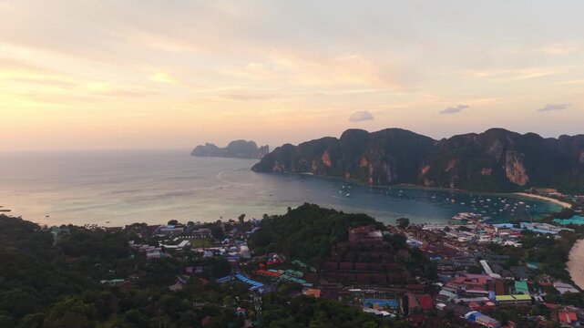 Aerial: golden hour colors of sunset in Koh Phi Phi Islands in the Strait of Malacca, Thailand, pan drone shot