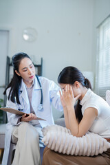 Fototapeta premium A doctor or nurse is talking to a patient sitting on a sofa in a private hospital room.