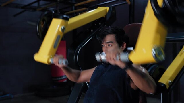 Athletic Man Using Resistance Machine for Shoulder and Upper Body Training. Shoulder Press Machine Workout with Focused Athlete in Gym.