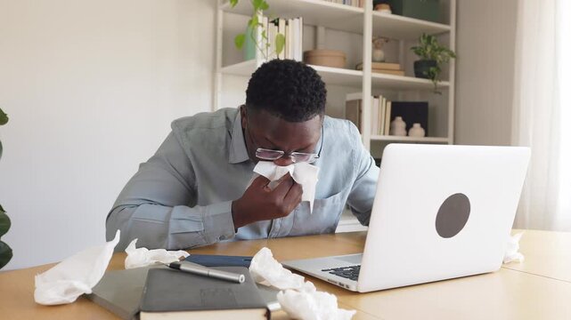 Sick african american man working with laptop