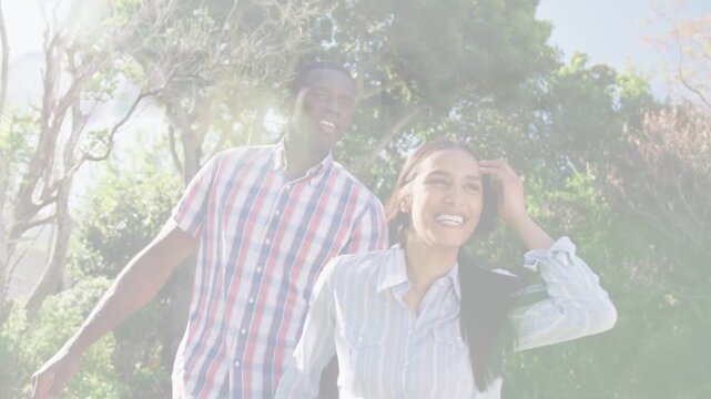Couple walking sunny path woman laughing and tucking hair man smiling lens flare boosting health ad