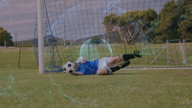 Soccer keeper diving after ball coming from left contacting, securing ball with globe around keeper