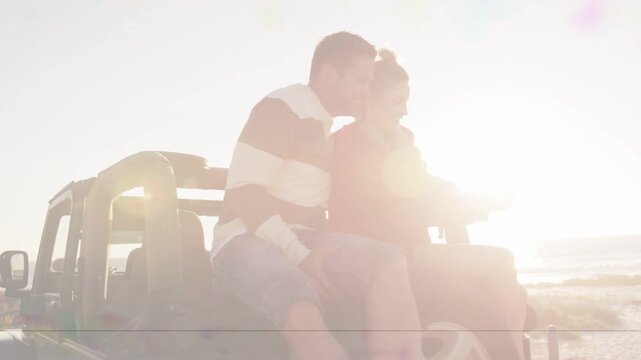 Woman extending phone framing sun selfie, man leaning in kissing her cheek, tech showing lens flare