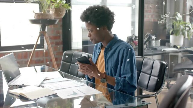 Business user reading smartphone then lifting phone to ear, answering call while referencing charts