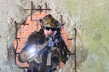 Obraz premium Tactical Soldier With Rifle Aiming Through Rubble In Urban Combat Training Scenario