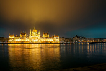 Fototapeta premium Budapest skyline featuring brightly lit Parliament building across the river